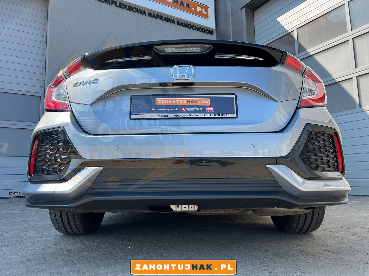 Zdjęcie przedstawia Hondę Civic z zamontowanym hakiem wypinanym ponowo Westfalia A40V, zdjęcie jest zrobione z tyłu samochodu i przedstawia wygląd zderzaka po zdemontowaniu kuli haka holowniczego 